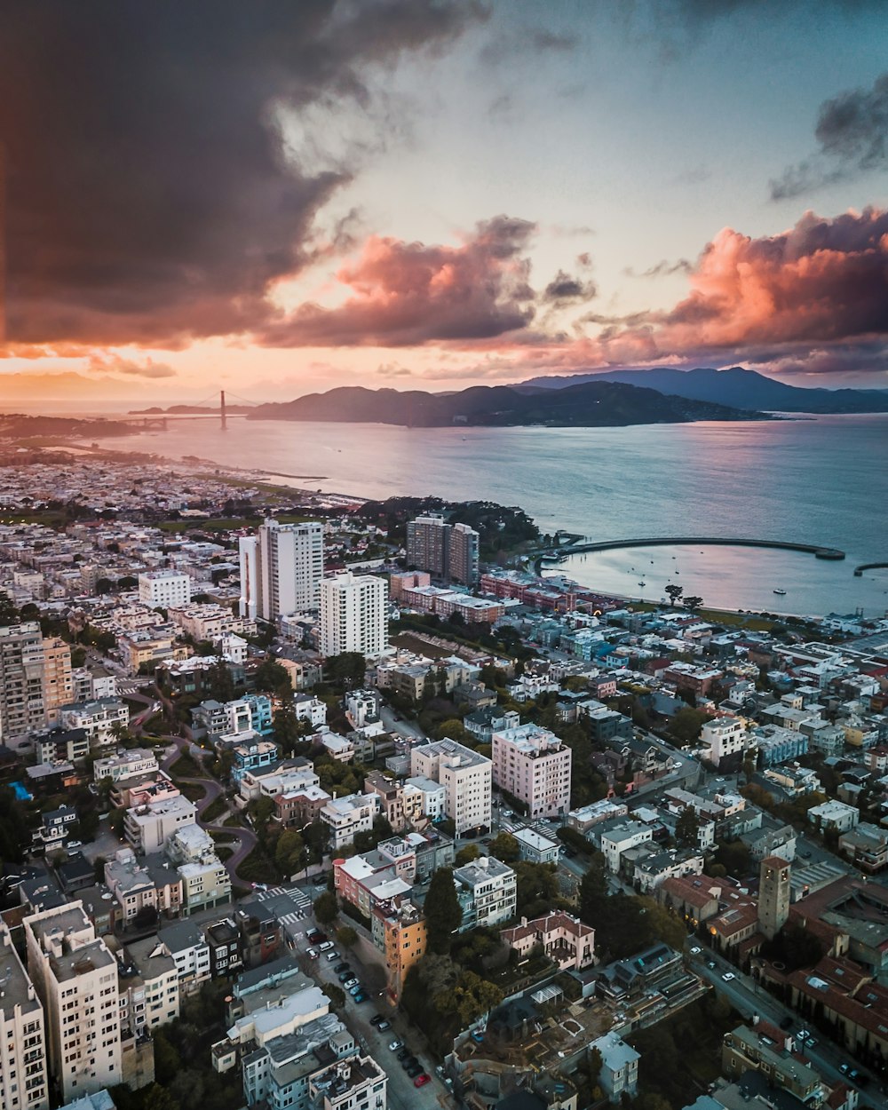 aerial photography city near sea under golden sky