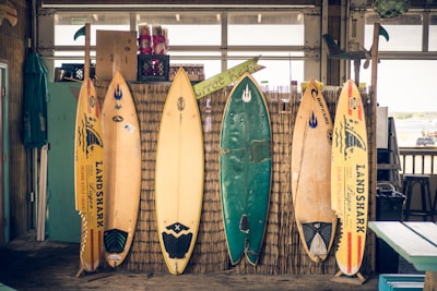 six assorted-color surfboards on brown board surf zoom background