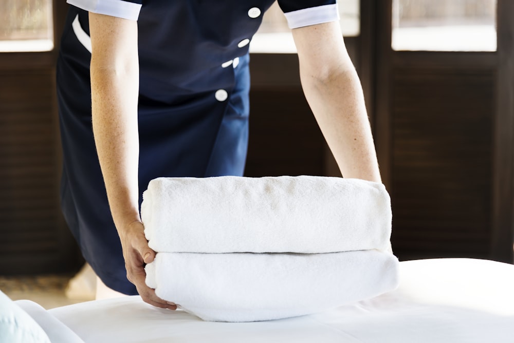 person holding two white towels