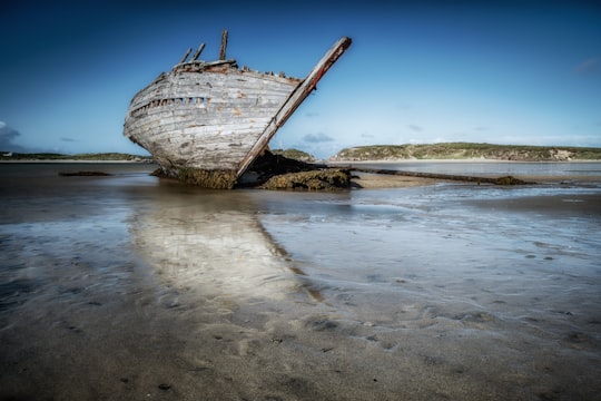 painting of boat docked on body of water in Magheraclogher Ireland