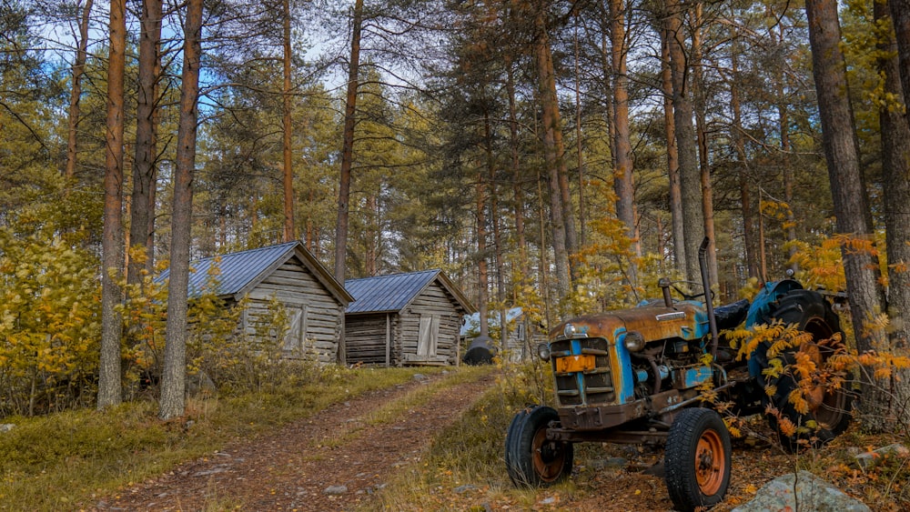 blue tractor beside cabin near trees