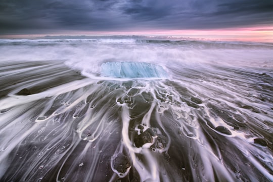 body of water under cloudy sky in Jökulsárlón Iceland