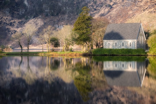 gray house near trees and body of water at daytime in Gougane Barra Ireland