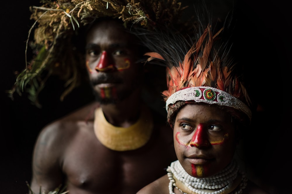 two man and woman standing beside each other while wearing headdress