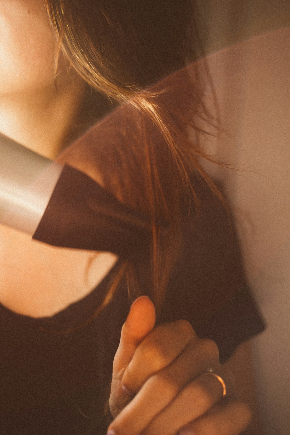 woman holding black and gray hair dryer