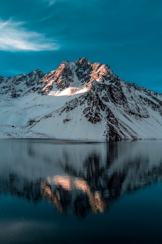 body of water near mountain coated by snow in El Yeso Dam Chile