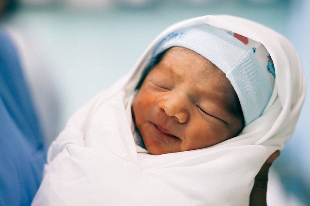 baby's covered with white swaddle