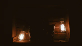 Warmly lit image of a handcrafted wooden memory box with engraved initials, surrounded by dried flowers.