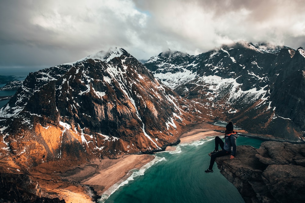 donna che si siede in cima alla scogliera