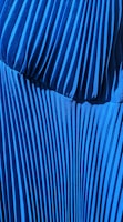 Close-up of a handmade pleated pant with rich navy fabric and detailed stitching.