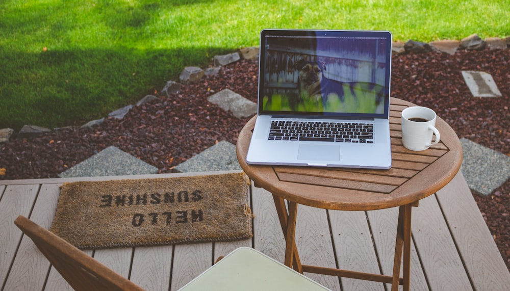 turned-on gray laptop computer on top of table