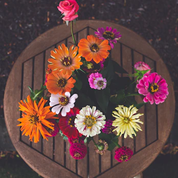 A variety of colorful artificial flower bouquets displayed on a wooden table