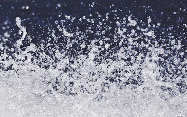 Dynamic shot of a powerful flower spray machine releasing a burst of shimmering mist under dark ambient lighting.