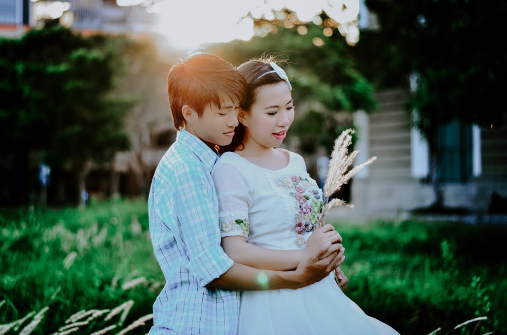 man hugging woman from behind selective focus photography