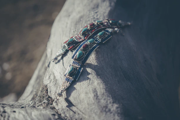 Close-up of hands weaving macramé jewelry with natural Mexican stones in warm light
