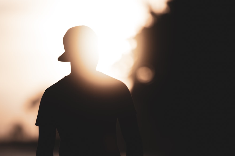 silhouette photography of person with hat