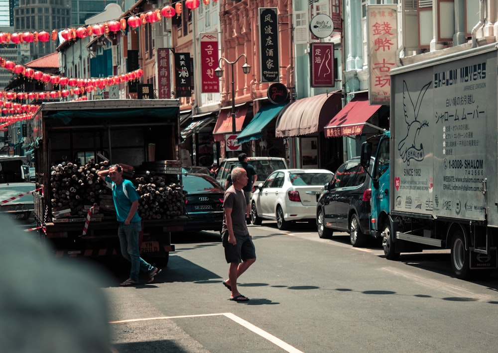 two men standing in road between building at daytime