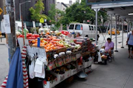 A street vendor selling fresh fruits and vegetables with colorful produce.