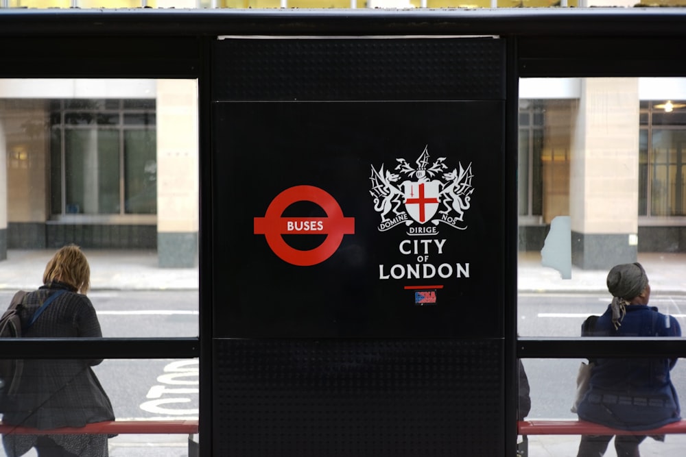 dos mujeres sentadas en el cobertizo de espera de la ciudad de Londres durante el día