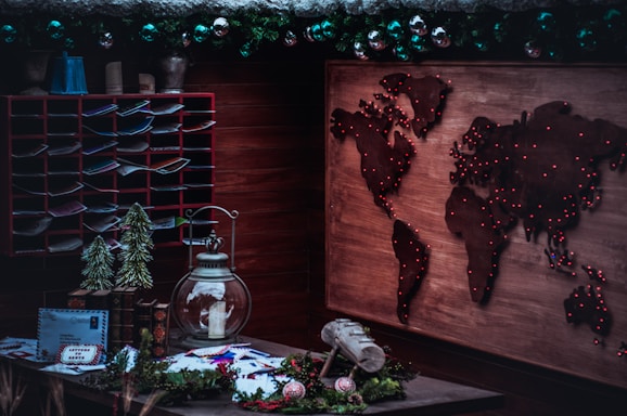 A cozy home office with travel maps and souvenirs scattered around, reflecting a personal travel agency vibe.