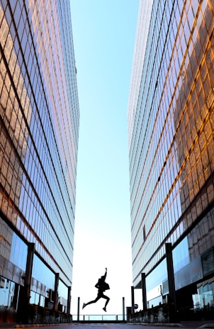 A happy young man jumping in the air with a bright city street behind him, symbolizing financial freedom.