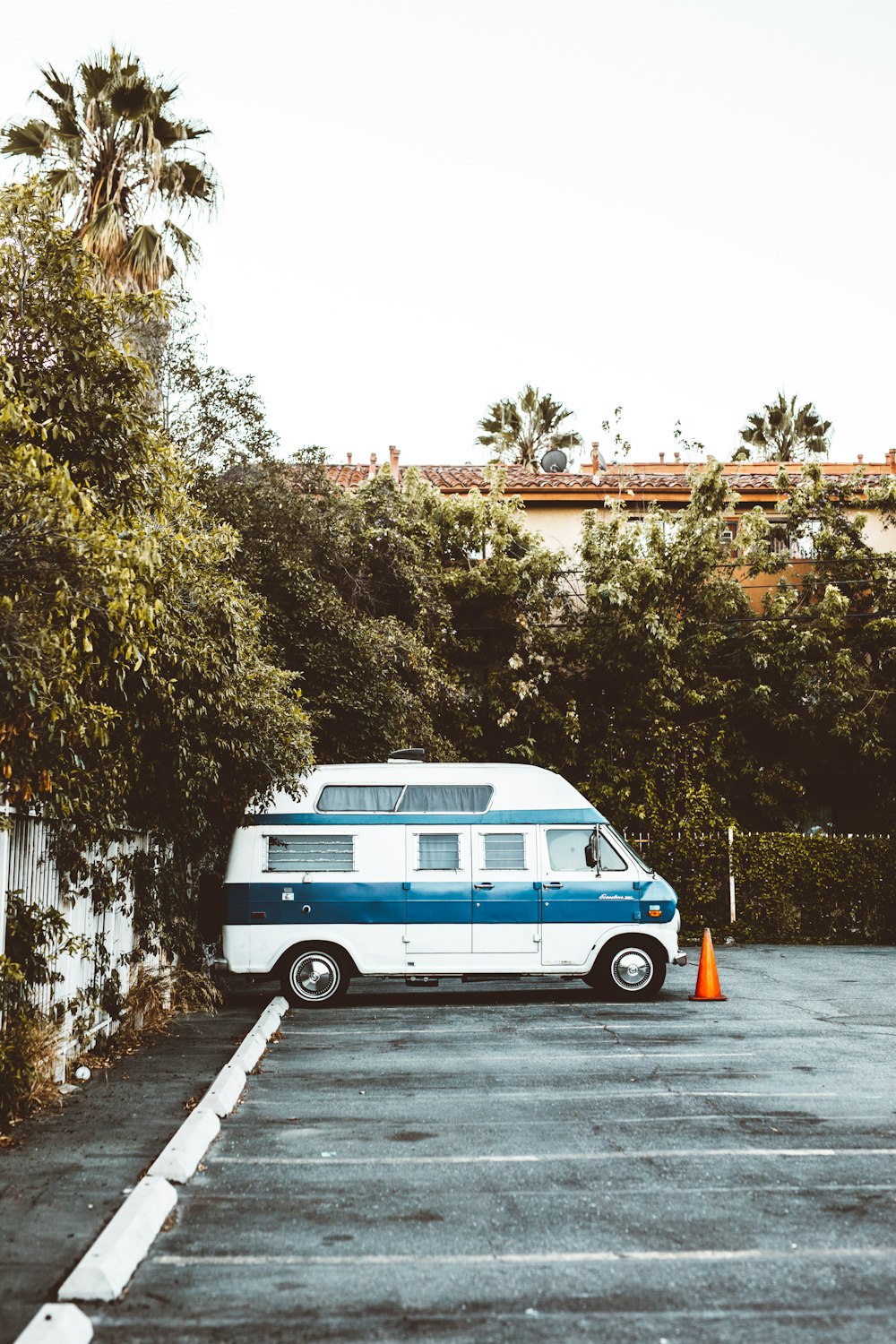 white and blue travel trailer parked on parking lot