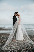 newly wedded couple standing on shore during daytime