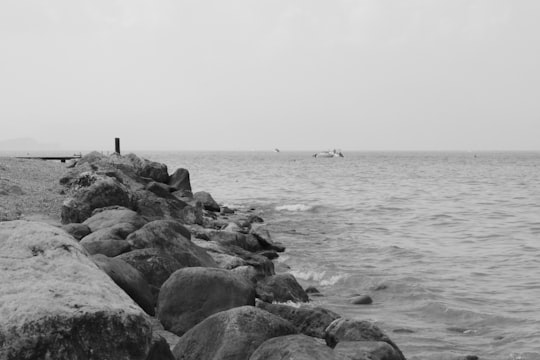 rocks near body of water grayscale photography in Lake Garda Italy