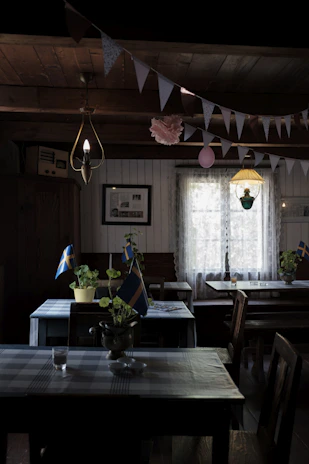 A cozy Scandinavian-style restaurant corner bathed in warm light, with fresh produce and rustic table settings.