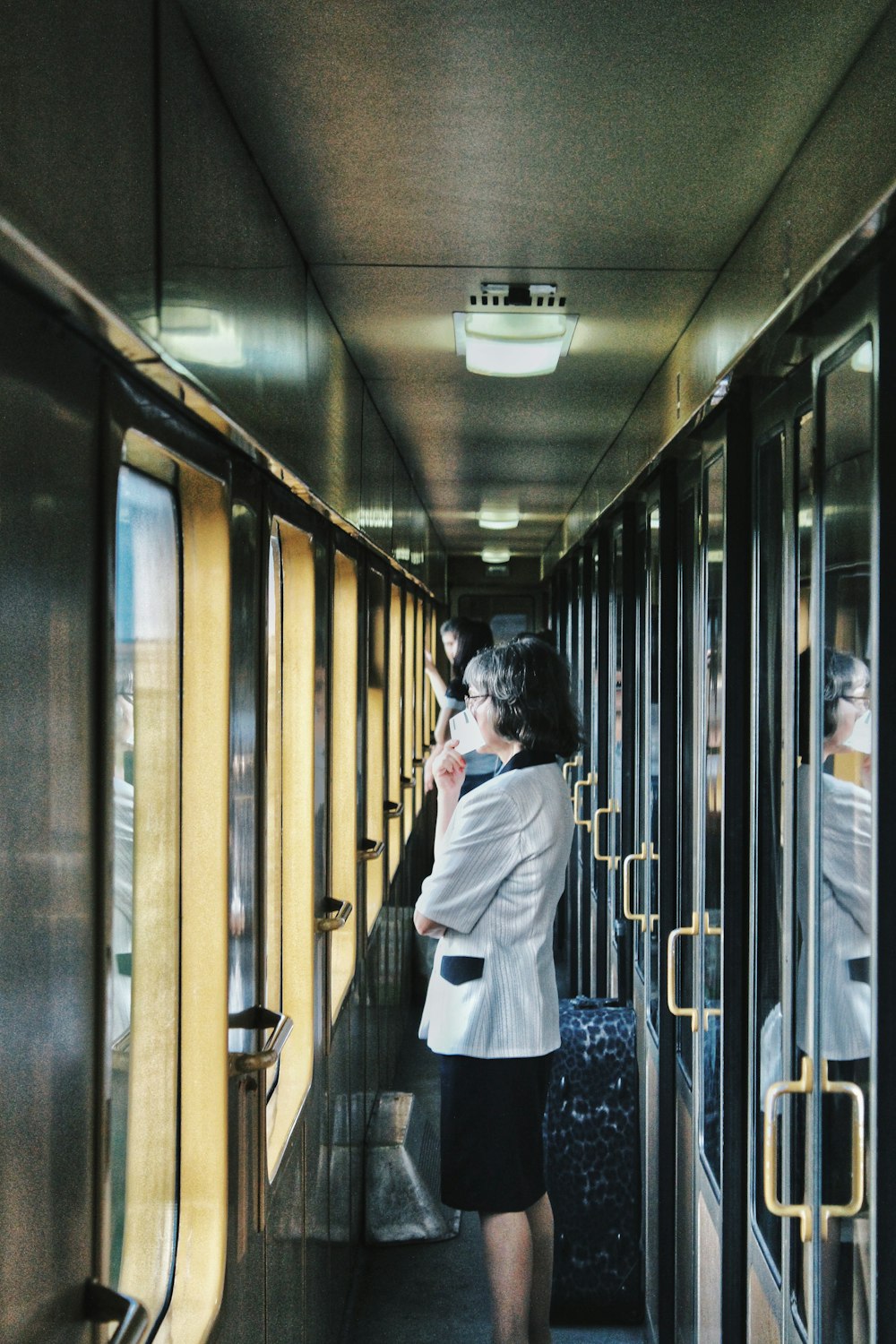 woman standing inside train facing window