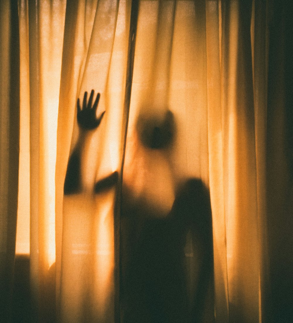 woman hiding behind of curtain