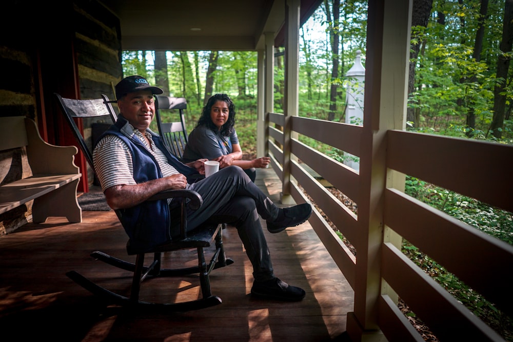 homme et femme assis sur des chaises berçantes en bois noir