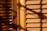 Wooden window blinds with horizontal slats are visible, with shadows cast across the surface. The lighting creates a warm and textured appearance, highlighting the natural grain of the wood.
