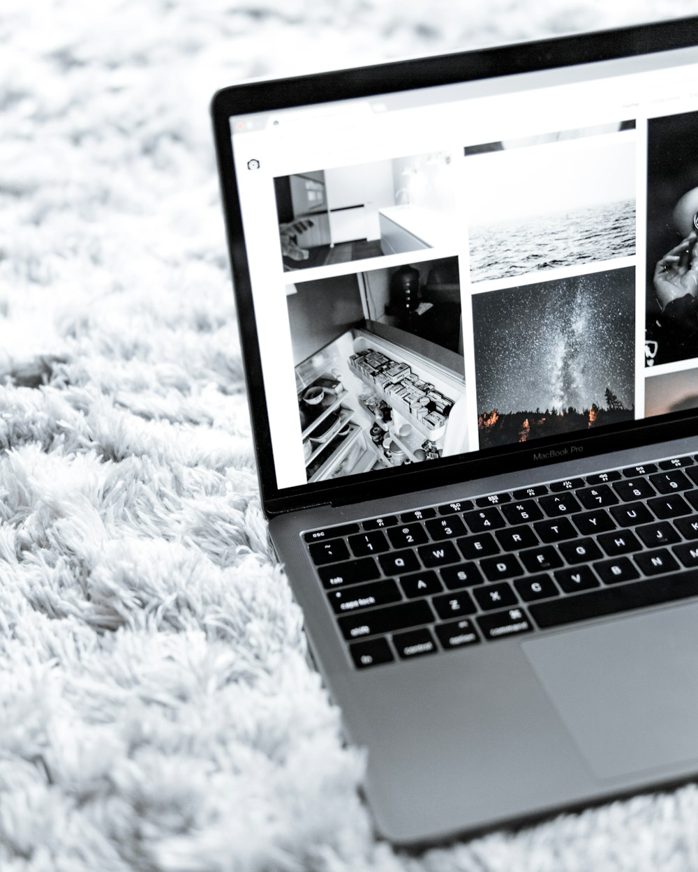 turned-on MacBook Pro on gray area rug