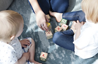 two toddler playing letter cubes