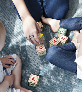 two toddler playing letter cubes