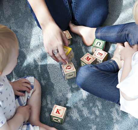 two toddler playing letter cubes