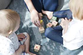 two toddler playing letter cubes