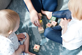 Crianças brincando com a mãe com jogo de letras