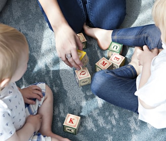 two toddler playing letter cubes