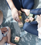 two toddler playing letter cubes