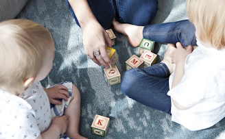 two toddler playing letter cubes