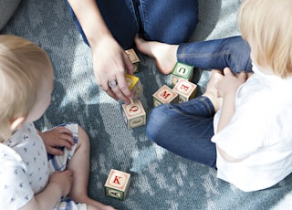 two toddler playing letter cubes