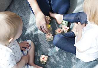 two toddler playing letter cubes