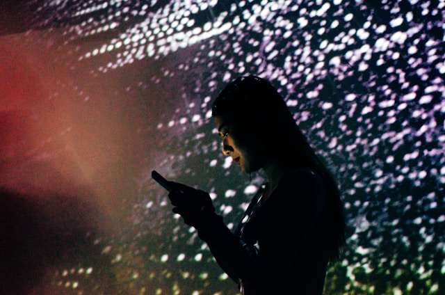 A sleek futuristic mobile gamer immersed in a glowing cosmic interface with neon cyan and magenta accents.