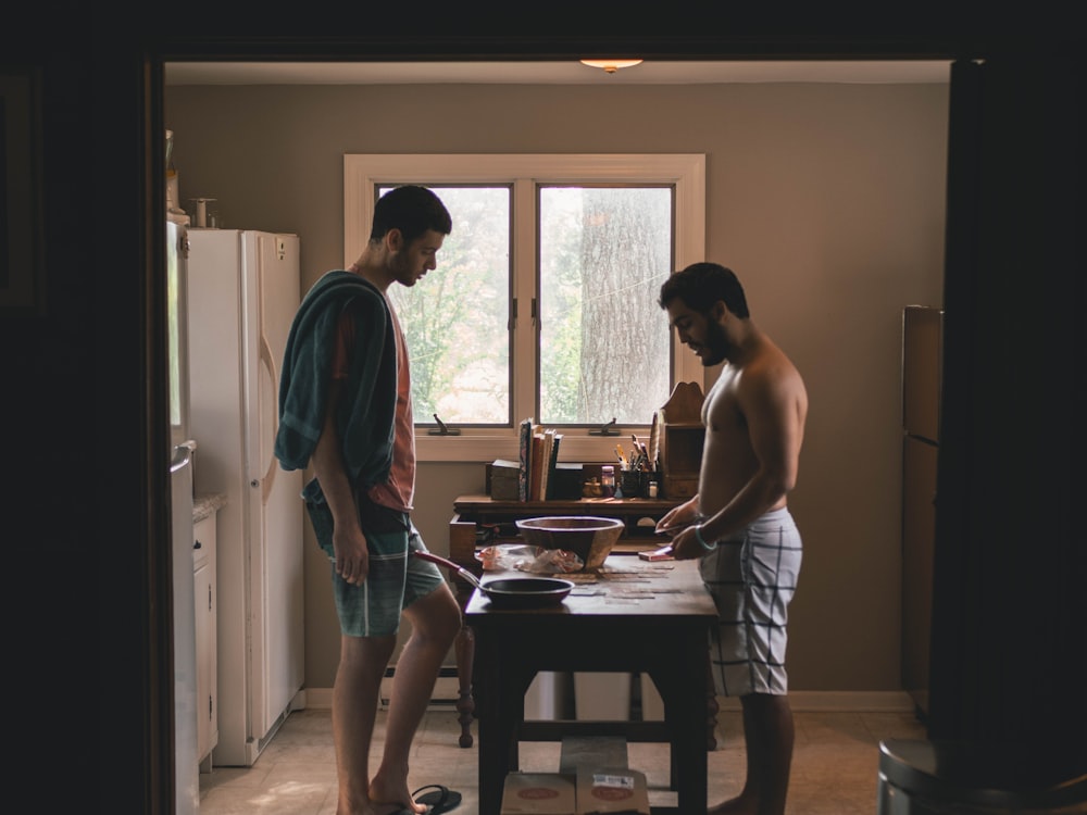 two men standing in front of table inside kitchen room