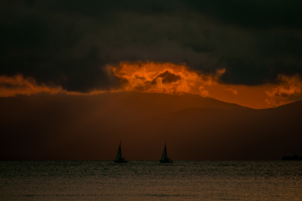 two silhouette of sail boats
