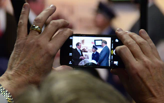 Close-up of hands registering on a digital tablet at a festive alumni event.