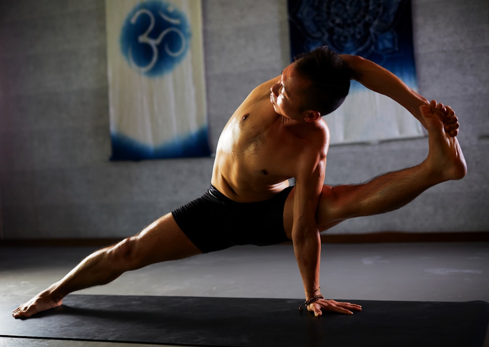 man stretching on black mat