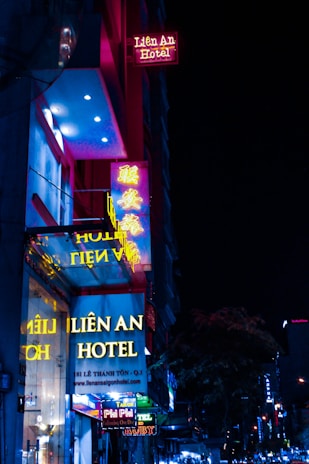 A sleek neon yellow-lit entrance of 7stonez hotel glowing against a crisp white and black rooftop under a twilight sky in Genting Highlands.